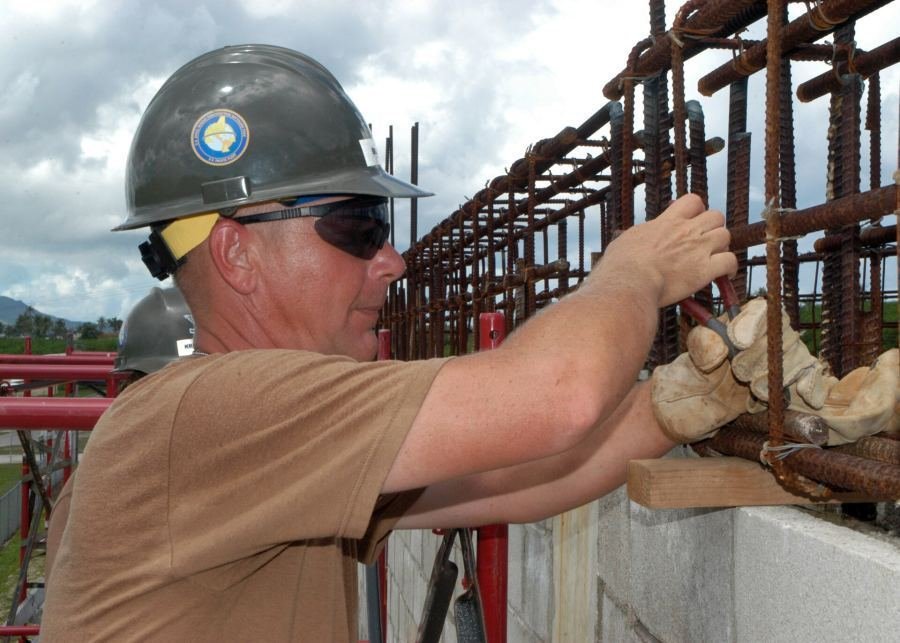 Construction worker tying reinforcement rebar for RCC structure
